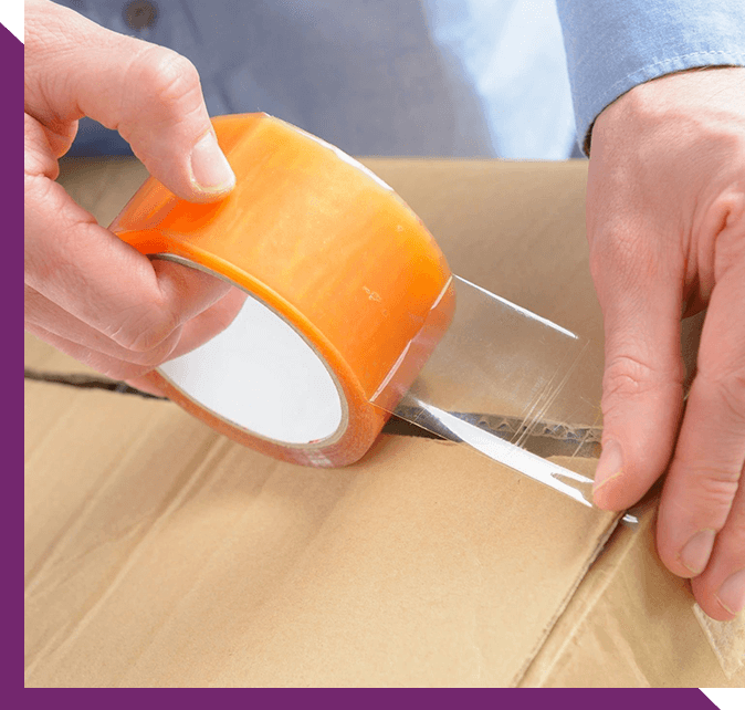 Hands With Roll of Transparent Packaging, Adhesive Tape on a Cardbox